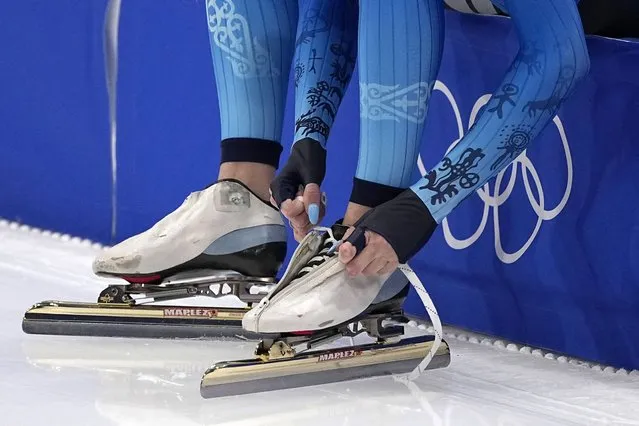 An athlete from Kazakstan laces her skates during warmups for the women's speedskating 1,500-meter race at the 2022 Winter Olympics, Monday, February 7, 2022, in Beijing. (Photo by Sue Ogrocki/AP Photo)