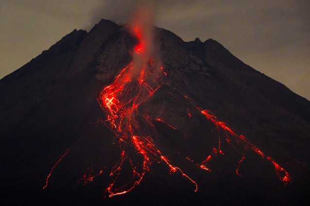 This long exposure photo taken on May 14, 2024 shows Mount Merapi spewing lava onto its slopes as seen from Srumbung, Central Java. (Photo by Devi Rahman/AFP Photo)