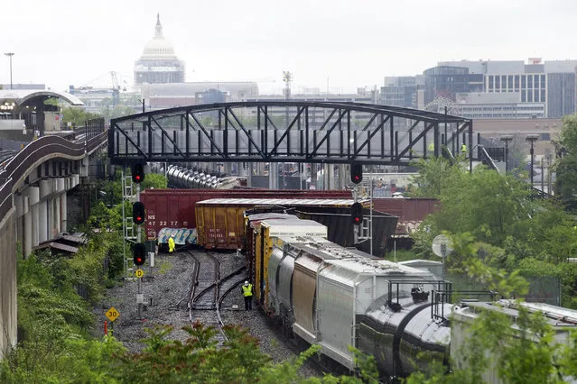 Emergency personnel work at the scene after a CSX freight train derailed, spilling hazardous material, in Washington on Sunday, May 1, 2016. The Capitol is seen in the background. (Photo by Cliff Owen/AP Photo)