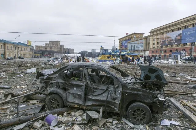 A damaged car sits at the central square following shelling of the City Hall building in Kharkiv, Ukraine, Tuesday, March 1, 2022. (Photo by Pavel Dorogoy/AP Photo)
