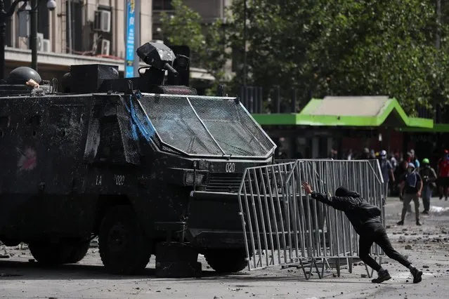 A demonstrator pushes a fence towards an armored vehicle during a protest against Chile's state economic model in Santiago, Chile on October 23, 2019. Chile is hit with more protests despite President Sebastian Pinera's pleas for forgiveness and announcement of ambitious reforms to quell unrest that has rocked the country and led to at least 15 deaths. (Photo by Ivan Alvarado/Reuters)