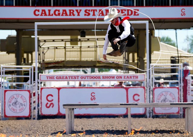 Rodeo entertainer Brinson James jumps through a lasso at the start of the rodeo event at the Calgary Stampede in Calgary, Alberta, Canada on July 8, 2024. (Photo by Todd Korol/Reuters)