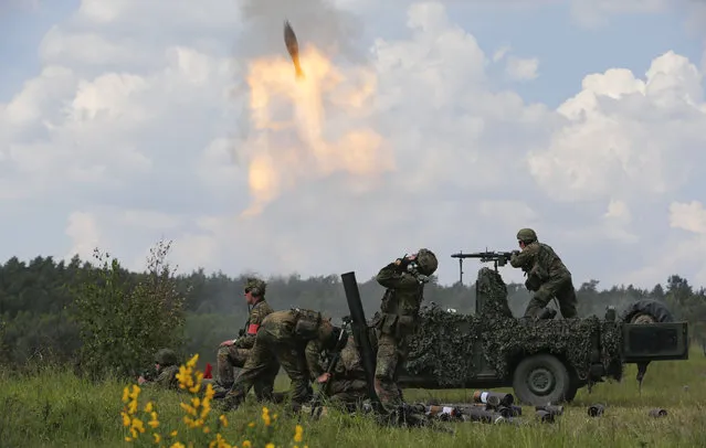 German armed forces Bundeswehr soldiers fire mortars during the JAWTEX 2014 (Joint Air Warfare Tactical Exercise) at an army training area in Bergen, May 20, 2014. About 4500 soldiers from eleven countries take part at the largest European military exercise in 2014. (Photo by Fabrizio Bensch/Reuters)