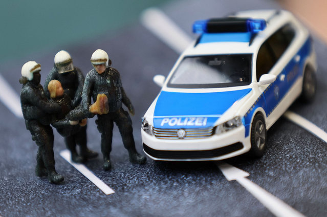 German riot policemen carry “Fridays For Future” activist Greta Thunberg in this 1:87 miniature model of "Greta and policemen”designed by the model making store owner Michael Huenerbein, in Aachen, Germany, April 28, 2023. The model made by a 3-D color printer depicts Swedish “Fridays For Future” climate change activist Greta Thunberg who has been carried away from an open-cast lignite mine near of German utility RWE by German riot policemen on January 17, 2023, during week-long protests against the clearing of the little village of Luetzerath some 40 km away from Aachen. (Photo by Wolfgang Rattay/Reuters)