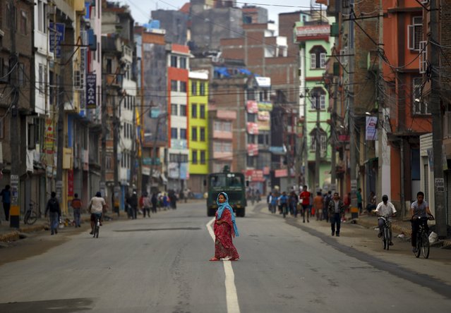 A woman cross the deserted road during the general strike called by the hardliner faction from the former Maoist rebels to protest against the first draft of the new constitution that has been published in Kathmandu July 24, 2015. (Photo by Navesh Chitrakar/Reuters)