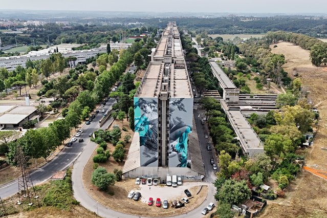 An aerial view shows 'Icarus' a murales by artist Judith de Leeuw aka JDL, painted on the lateral wall of the “Serpentone” (The Big Snake), a one-kilometer residential complex designed in the 70's in Corviale neighborhood in Rome, on July 3, 2024. (Photo by Andreas Solaro/AFP Photo)