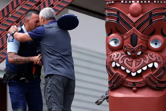 A police officer hugs a man after Ngati Awa representatives and relatives of the volcano eruption victims leave a ceremony called “Karakia” at Mataatua Marae house in Whakatane, New Zealand, December 12, 2019. (Photo by Jorge Silva/Reuters)