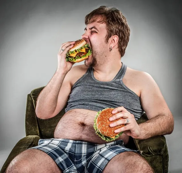 Fat man eating hamburger. (Photo by Andrey Armyagov /Getty Images)