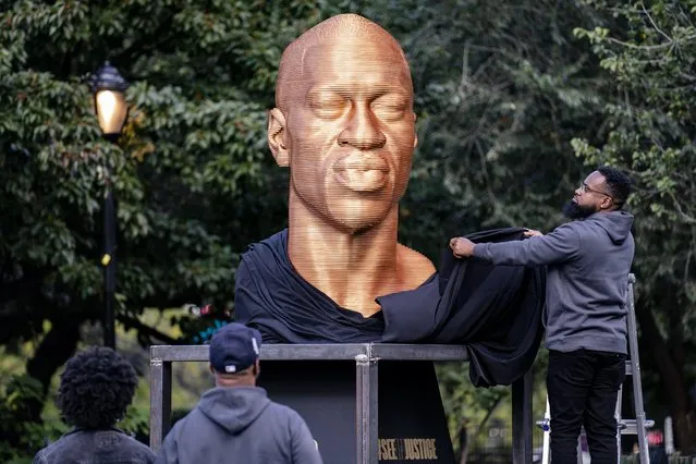 A sculpture of George Floyd, one of three sculptures as part of the “SEEINJUSTICE” art exhibition that also feature the likenesses of Breonna Taylor and John Lewis, is unveiled as Floyd's brother Terrence, second from left, looks on, Thursday, September 30, 2021, at Union Square in the Manhattan borough of New York. The exhibition will be on public display at the square for one month and is intended to “to raise awareness of racism and actions for correction”. (Photo by John Minchillo/AP Photo)