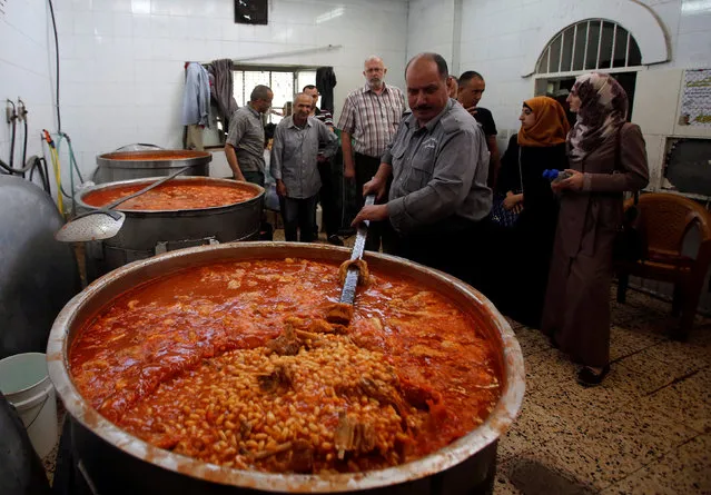 Palestinians prepare food to be distributed for free during the holy fasting month of Ramadan in the West Bank city of Hebron June 13, 2016. (Photo by Mussa Qawasma/Reuters)