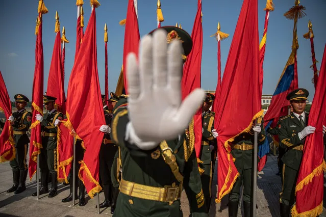 A member of an honor guard gestures to the photographer to stop taking photos prior to a welcome ceremony for Colombian President Ivan Duque Marquez at the Great Hall of the People in Beijing, China, 31 July 2019. Colombian President Ivan Duque Marquez is on a state visit to China from 28 July to 31 July 2019. (Photo by Roman Pilipey/EPA/EFE)