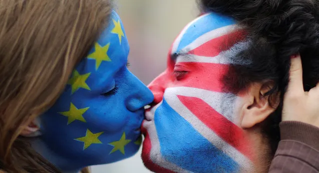 Two activists with the EU flag and Union Jack painted on their faces kiss each other in front of Brandenburg Gate to protest against the British exit from the European Union, in Berlin, Germany, June 19, 2016. (Photo by Hannibal Hanschke/Reuters)