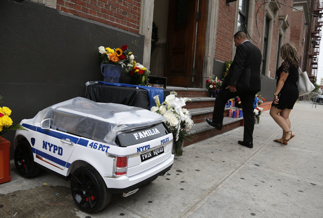 Tributes to police officer Miosotis Familia are seen in front of the 46th Precinct in the Bronx borough of New York, Thursday, July 6, 2017. Familia was shot to death early Wednesday, ambushed inside her command post by an ex-convict, authorities said. He was later killed after pulling a gun on police. (Photo by Seth Wenig/AP Photo)