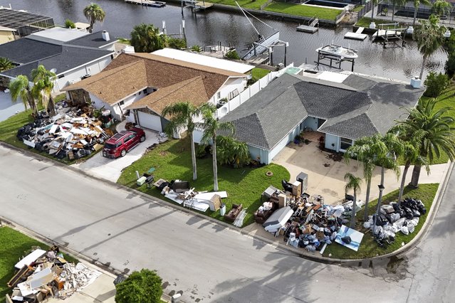 Debris from homes flooded in Hurricane Helene is piled curbside as Hurricane Milton approaches on Tuesday, October 8, 2024, in Port Richey, Fla. (Photo by Mike Carlson/AP Photo)