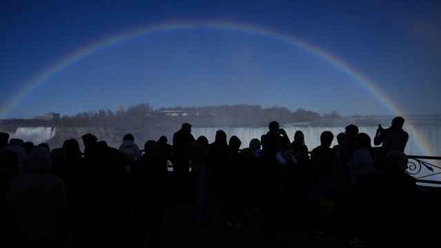 People view a rainbow at Niagara Falls, Ontario, Sunday, April 7, 2024. (Photo by Matt Rourke8AP Photo)