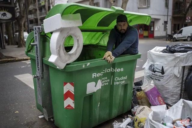 Francisco Leiva, 28, poses for a photo from inside a garbage container while recycling cardboard, plastics and metal to sell in Buenos Aires, Argentina, Monday, July 4, 2022. About four of every 10 Argentines are poor. (Photo by Rodrigo Abd/AP Photo)