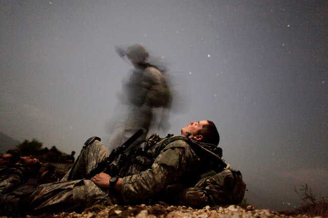 A U.S. soldier of 2-12 Infantry 4BCT-4ID Task Force Mountain Warrior takes a break during a night mission near Honaker Miracle camp at the Pesh valley of Kunar Province August 12, 2009. (Photo by Carlos Barria/Reuters)
