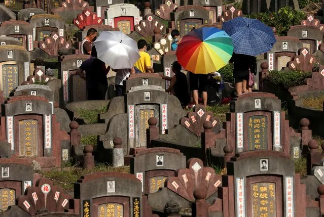 People tend to a grave ahead of Qingming Festival, or Tomb Sweeping Day at a Chinese cemetery in Kuala Lumpur, Malaysia on April 3, 2022. (Photo by Hasnoor Hussain/Reuters)