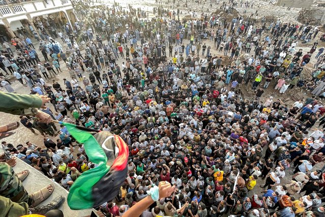 People gather for a demonstration outside the surviving Al-Sahaba mosque in Libya's eastern city of Derna on September 18, 2023, as they protest against government neglect to the two dams which broke and led to the deadly flash floods that hit the city the prior week. A week after a tsunami-sized flash flood devastated the Libyan coastal city of Derna, sweeping thousands to their deaths, the international aid effort to help the grieving survivors slowly gathered pace. The enormous flood, fuelled by torrential rains on September 10, had broken through two upstream dams and sent a giant wave crashing down the previously dry river bed, or wadi, that bisects the city of about 100,000 people. (Photo by Hussam Ahmed/AFP Photo)