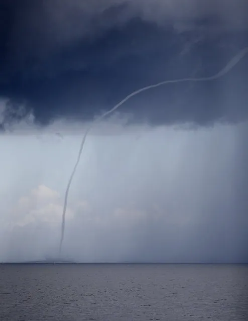 A waterspout dissipates on Lake Pontchartrain, as storm clouds enter the area in New Orleans, Tuesday, July 12, 2016. (Photo by Gerald Herbert/AP Photo)