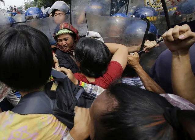 Filipino protesters scuffle with police as they tried to march towards the U.S. Embassy in Manila, Philippines on Friday, September 15, 2017. The groups is protesting against the alleged increasing intervention of the U.S. military in the ongoing war in Marawi and growing presence in Mindanao. (Photo by Aaron Favila/AP Photo)