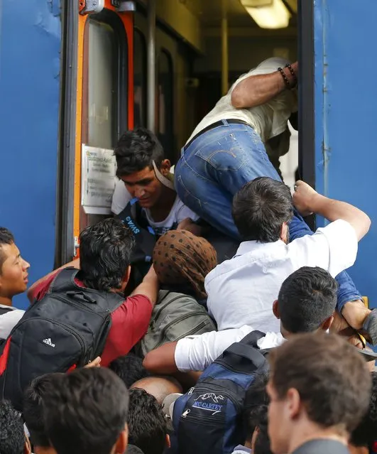 Migrants storm into a train at the Keleti train station in Budapest, Hungary, September 3, 2015 as Hungarian police withdrew from the gates after two days of blocking their entry. (Photo by Laszlo Balogh/Reuters)