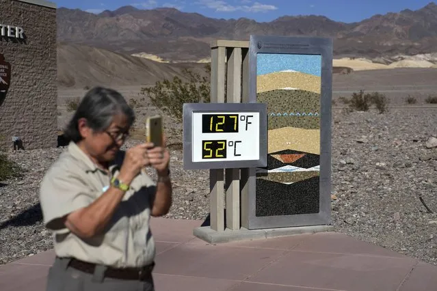 People visit a thermometer at the Furnace Creek Visitor Center, Thursday, September 1, 2022, in Death Valley National Park, Calif. The thermometer is not official but is a popular photo spot. (Photo by John Locher/AP Photo)