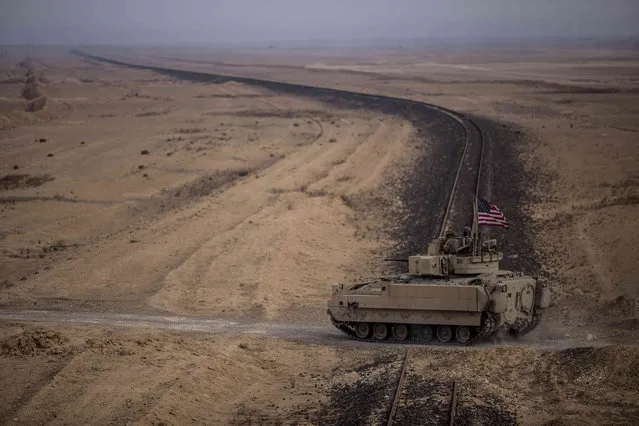 American soldiers drive a Bradley fighting vehicle during a joint exercise with Syrian Democratic Forces at the countryside of Deir Ezzor in northeastern Syria, Wednesday, December 8, 2021. (Photo by Baderkhan Ahmad/AP Photo)