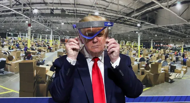 U.S. President Donald Trump holds up a protective face shield during a tour of the Ford Rawsonville Components Plant that is manufacturing ventilators, masks and other medical supplies during the coronavirus disease (COVID-19) pandemic in Ypsilanti, Michigan, U.S., May 21, 2020. (Photo by Leah Millis/Reuters)