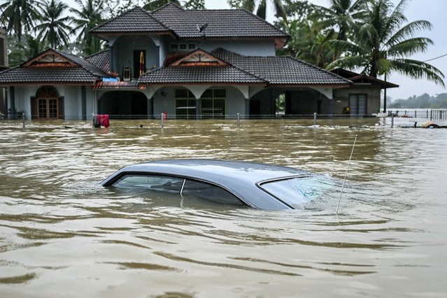 A submerged car is covered by flood waters after days of heavy rain in Tumpat in Malaysia's Kelantan state on November 30, 2024. (Photo by Mohd Rasfan/AFP Photo)