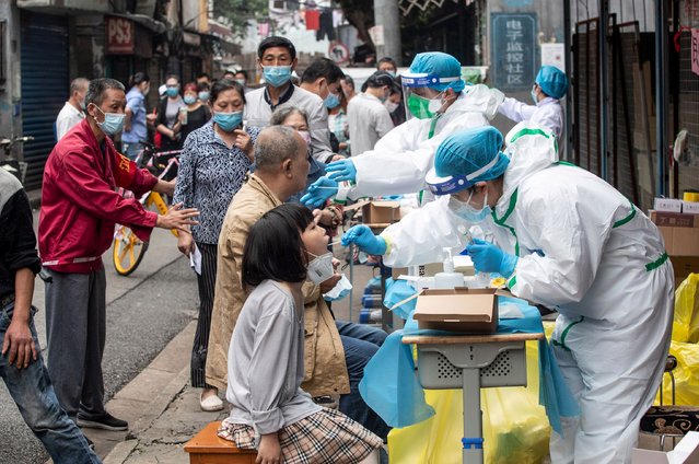 Medical workers take swab samples from residents to be tested for the COVID-19 coronavirus, in a street in Wuhan in China's central Hubei province on May 15, 2020. Authorities in the pandemic ground zero of uhan have ordered mass COVID-19 testing for all 11 million residents after a new cluster of cases emerged over the weekend. (Photo by AFP Photo/China Stringer Network)