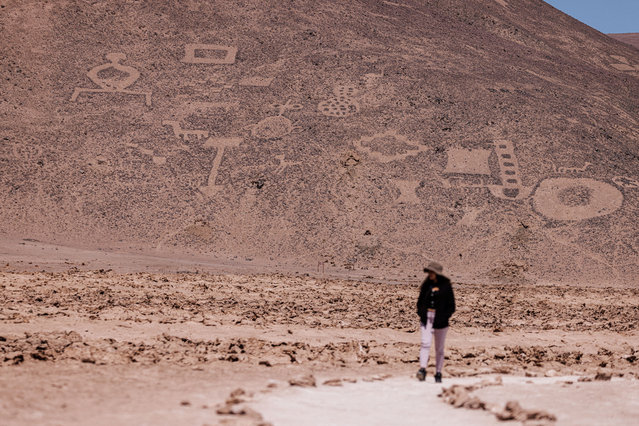 A visitor walks past the ancient geoglyphs of “Cerros Pintados”, at Atacama desert, in Iquique, Chile on October 29, 2024. (Photo by Ivan Alvarado/Reuters)