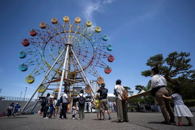 Visitors wait in line to ride the ferris wheel at the Tochinoki Family Land amusement park on May 17, 2020 in Utsunomiya, Tochigi, Japan. Japan's Prime Minister Shinzo Abe announced on May 14 that the nationwide state of emergency has been lifted for 39 of the country's 47 prefectures after the number of new Covid-19 coronavirus cases decreased. However, Hokkaido, Tokyo, Kanagawa, Saitama, Chiba, Osaka, Kyoto and Hyogo will remain under the order until May 31. (Photo by Tomohiro Ohsumi/Getty Images)
