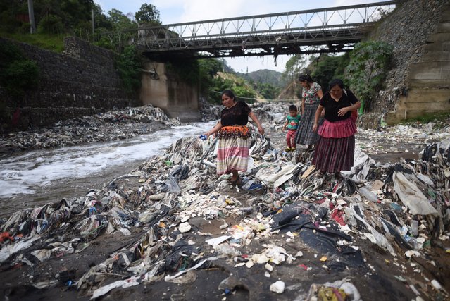 Women recover materials from the garbage on the polluted Las Vacas River, a tributary of the Motagua River, in Santa Cruz Chinautla, Guatemala, 08 June 2022. The Dutch environmental organization The Ocean Cleanup assured that it intends to place a fence that will help clean the garbage of the Motagua River in Guatemala, which it considers one of the most polluted on the planet. “Our mission is to rid the oceans of garbage and that is why we are working on one of the most polluting watersheds in the world and turning it into one of the cleanest”, its director, Boyan Slat, told Efe. (Photo by Edwin Bercián/EPA/EFE)