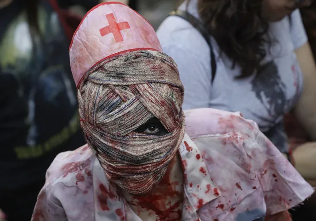 In this November 2, 2017 photo, a participant in costume takes part in the Zombie Walk in Sao Paulo, Brazil. Participants commemorated the Day of the Dead with the annual Zombie Walk. (Photo by Andre Penner/AP Photo)