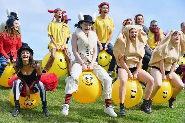 Comedians and cast members from the Pleasance's 2016 programme bounce on yellow spacehoppers in costume at Calton Hill on August 15, 2016 in Edinburgh, Scotland. (Photo by Jeff J. Mitchell/Getty Images)