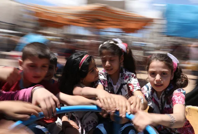 Children celebrate Eid al-Fitr in the rebel held town of Idlib, Syria, 25 May 2020. Muslims around the world are celebrating Eid al-Fitr, the three day festival marking the end of the Muslim holy fasting month of Ramadan. Eid al-Fitr is one of the two major holidays in Islam. (Photo by Yehya Nemah/EPA/EFE)