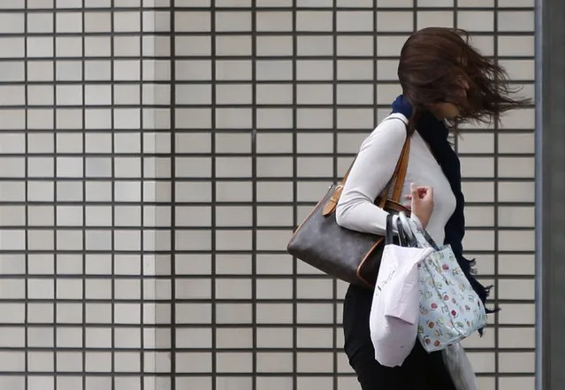 A woman's hair blows across her face as she struggles to walk in a strong wind caused by Typhoon Phanfone on a street in Tsu, Mie Prefecture, western Japan October 6, 2014. Hundreds of flights were cancelled and thousands of people advised to evacuate as a powerful typhoon lashed Japan on Monday with heavy rains and high winds, leaving at least one person dead as it headed towards Tokyo. (Photo by Yuya Shino/Reuters)