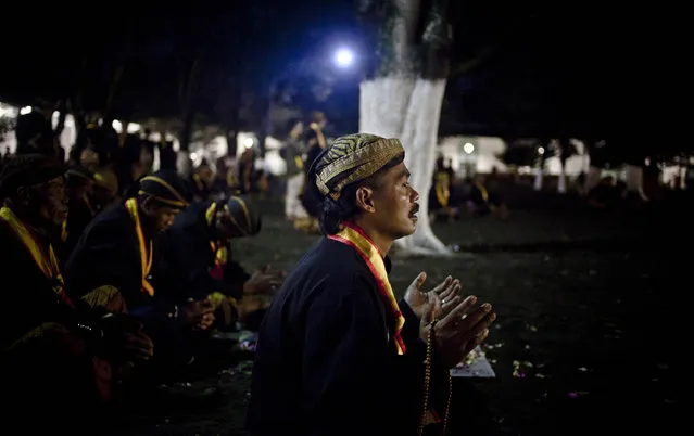 Javanese people pray before rituals night carnival “1st Suro” ( Javanese calender) during  Islamic New Year celebrations at Kasunanan Palace on November 14, 2012 in Solo City, Central Java, Indonesia. Javanese will celebrate the national holiday with ceremonies and rituals marking the 1434th Islamic New Year's Eve or “1st Suro”. The parade started from Keraton Kasunanan and is headed by a group of albino buffaloes, known as Kebo Bule. Local people believe that the parade of Heirlooms and Kebo Bule will bring them a better life. (Photo by Ulet Ifansasti)