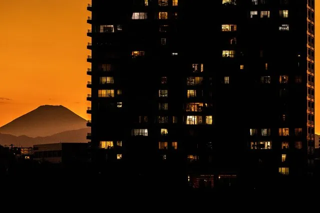 Mount Fuji (back L), Japan's highest mountain, is seen behind the residential buildings of Kawasaki, from Tamagawa Green Zone Baseball Field in Tokyo on October 26, 2022. (Photo by Philip Fong/AFP Photo)
