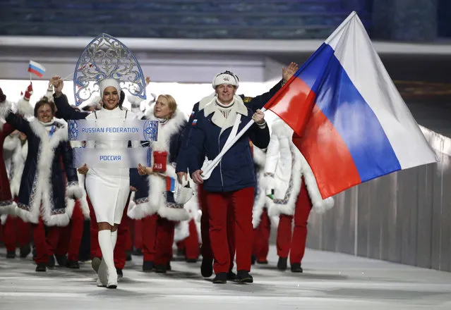 In this February 7, 2014 file photo Alexander Zubkov of Russia carries the national flag as he leads the team during the opening ceremony of the 2014 Winter Olympics in Sochi, Russia. When the International Olympic Committee board prepares to vote Tuesday, December 5, 2017 on whether to ban Russia from February’s Winter Olympics, its members will decide the fate of numerous medals yet to be won. (Photo by Mark Humphrey/AP Photo)