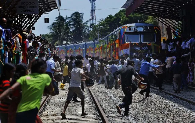 Sri Lankan ethnic Tamils rush towards the train “Queen of Jaffna”, after it arrived at Jaffna in Sri Lanka, Monday, October 13, 2014. The once-popular train linking the ethnic Tamil's northern heartland to the rest of Sri Lanka arrived in Jaffna, 24 years after its suspension due to the country’s civil war. (Photo by Eranga Jayawardena/AP Photo)