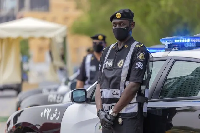 Policemen wearing gloves and face masks to help prevent the spread of the coronavirus, provide security for pilgrims, in Mecca, Saudi Arabia, Sunday, July 26, 2020. Only about 1,000 pilgrims will be allowed to perform the annual hajj pilgrimage that begins later this month due to the virus pandemic. (Photo y Saudi Ministry of Media via AP Photo)