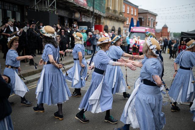 Morris dancers with the “Milltown Cloggies” attend the Joint Morris Organisations' annual “National Day of Dance” in Stockport, north west England on April 26, 2025. With around 1000 dancers expected to attend, the National Day of Dance is a collaborative event organised in turn by one of the three morris organisations in the UK – The Morris Federation, The Morris Ring, and Open Morris. The day of dance is a celebration of morris and traditional dancing held annually at a different location around the UK. (Photo by Oli Scarff/AFP Photo)