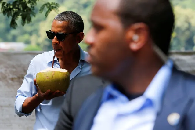 A Secret Service agent keeps watch as U.S. President Barack Obama drinks water of a fresh-cut coconut on a walk in Luang Prabang, Laos September 7, 2016. (Photo by Jonathan Ernst/Reuters)