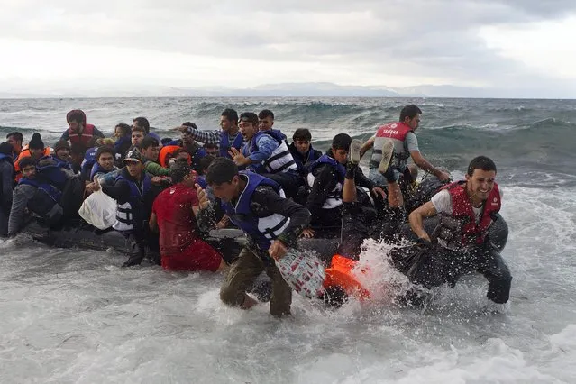 Refugees and migrants struggle to jump off an overcrowded dinghy on the Greek island of Lesbos, after crossing in rough seas from the Turkish coast, October 2, 2015. (Photo by Dimitris Michalakis/Reuters)