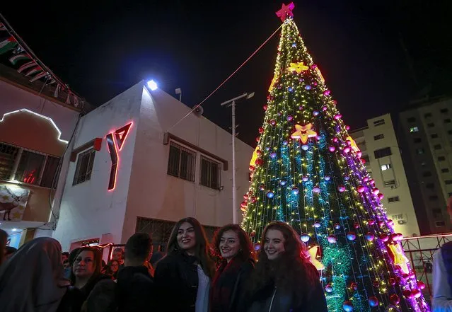 Palestinians attend a Christmas tree lighting ceremony in Gaza City, 10 December 2022. The event was organized by the non-governmental organization YMCA in Gaza. (Photo by Mohammed Saber/EPA/EFE)