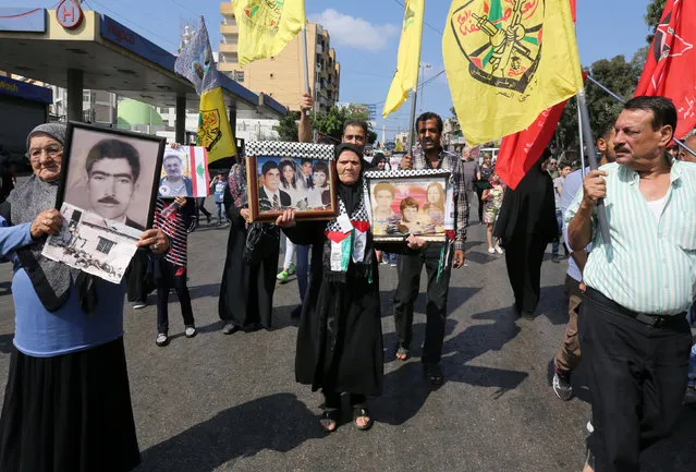 Palestinian women hold portraits showing images of relatives, who they say were killed during the Sabra and Shatila massacre, at a march to mark the 34th anniversary of the massacre in Beirut, Lebanon September 16, 2016. (Photo by Aziz Taher/Reuters)