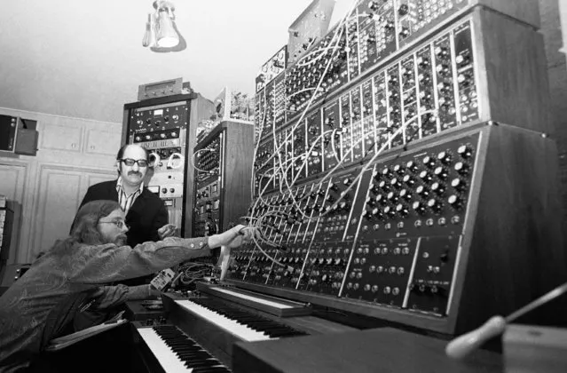 This array of keyboards, patch cords, knobs, dials, flashing lights and tape recorders is called a Moog synthesizer, a device which Mort Garson, rear, says an simulate any sound, musical or nonmusical. Operating the equipment is Gene Hamblin, January 27, 1971. There are several hundred similar devices, made by Robert Moog of Trumansburg, N.Y., around the country, mostly in colleges teaching electronic music. (Photo by David F. Smith/AP Photo)