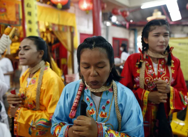 Female devotees to the Chinese Shrine of Jui Tui work themselves into a state of trance prior to a street parade during the annual Vegetarian Festival on Phuket Island, Thailand, 19 October 2015. The festival, which has Chinese origins, is held during the ninth lunar month of the Chinese calendar and it involves the beliefs of cleansing the body, ritual piercing, spirit medium, and the consumption of only vegetarian food as well as making merit. (Photo by Rungroj Yongrit/EPA)